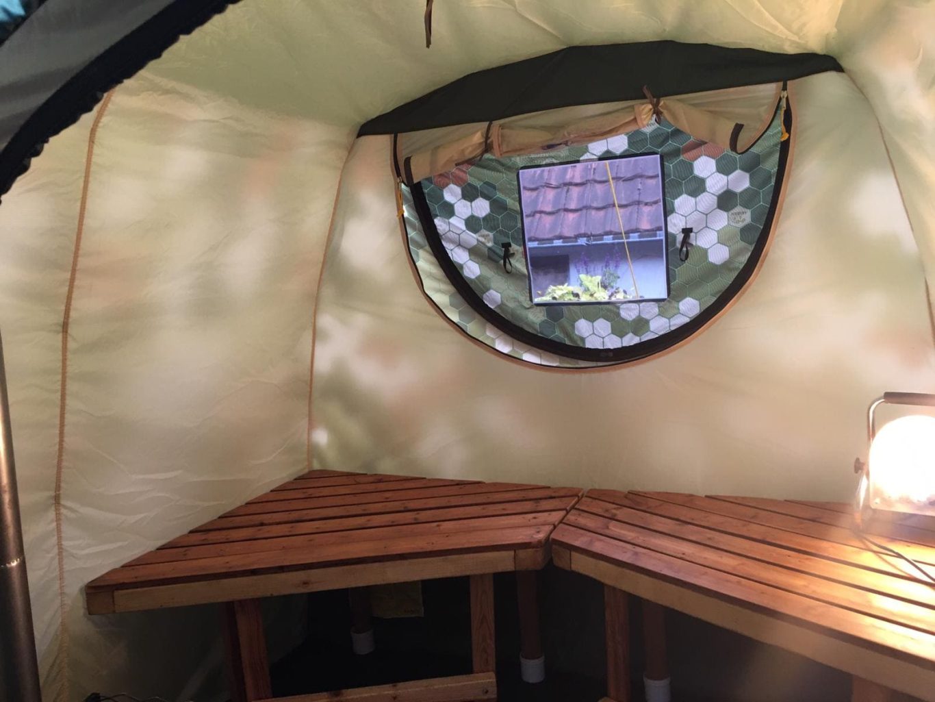 Mobiba MB-22 m³ – Innenraum Innenansicht der Mobiba MB-22 m³ Zeltsauna mit selbstgebauten Holzbänken und Fenster an der Rückwand.