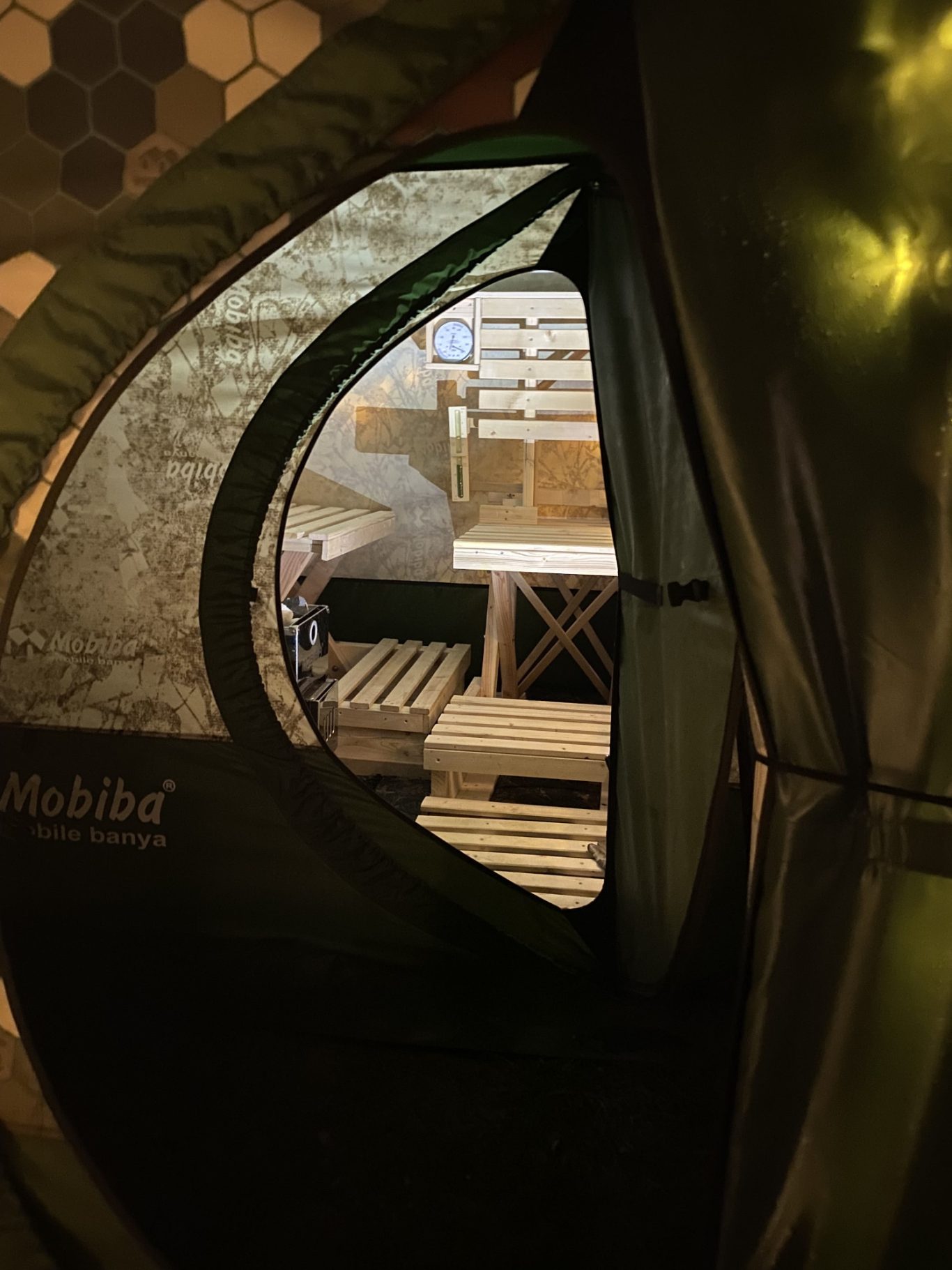 Blick ins Mobiba MB-10A1 durch das Überzelt ZP-10A1 Aufnahme durch den Eingang des Überzelts: Durch die zweite Tür sieht man den Innenraum des Mobiba MB-10A1 mit selbstgebauten Holzbänken.